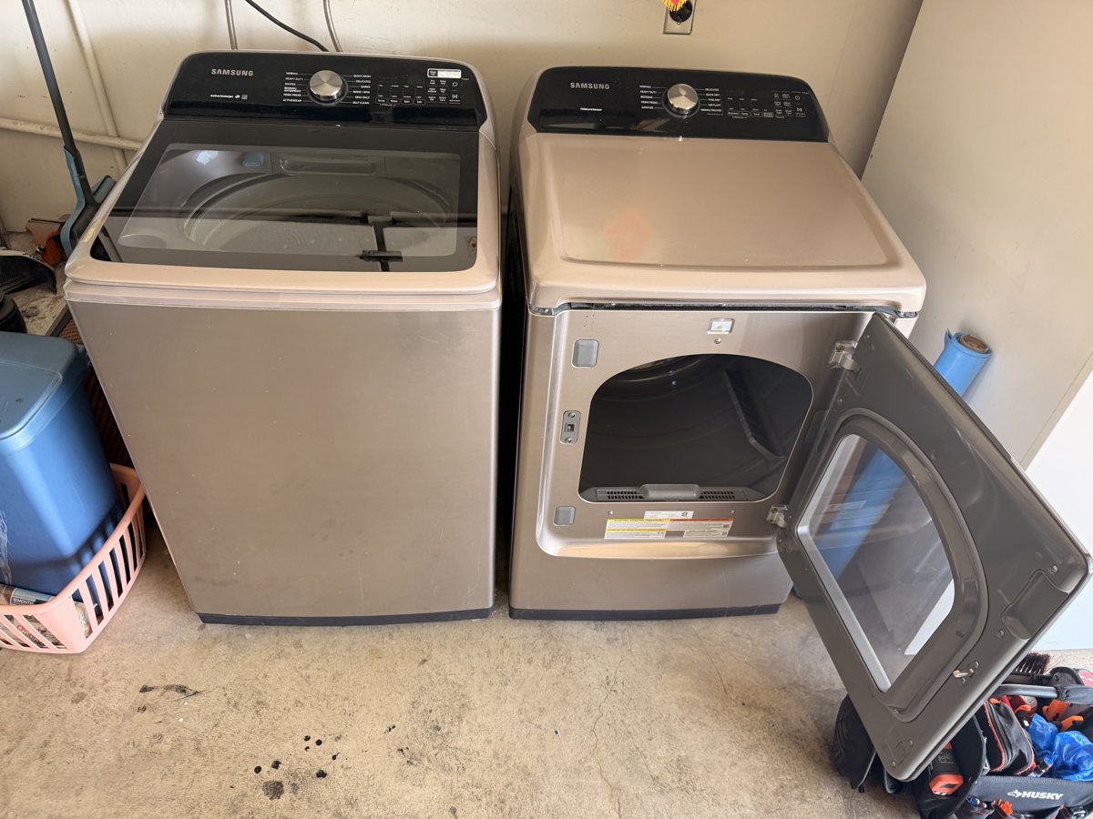Era Service technician repairing a dryer with the cabinet opened in a the Inland Empire laundry room